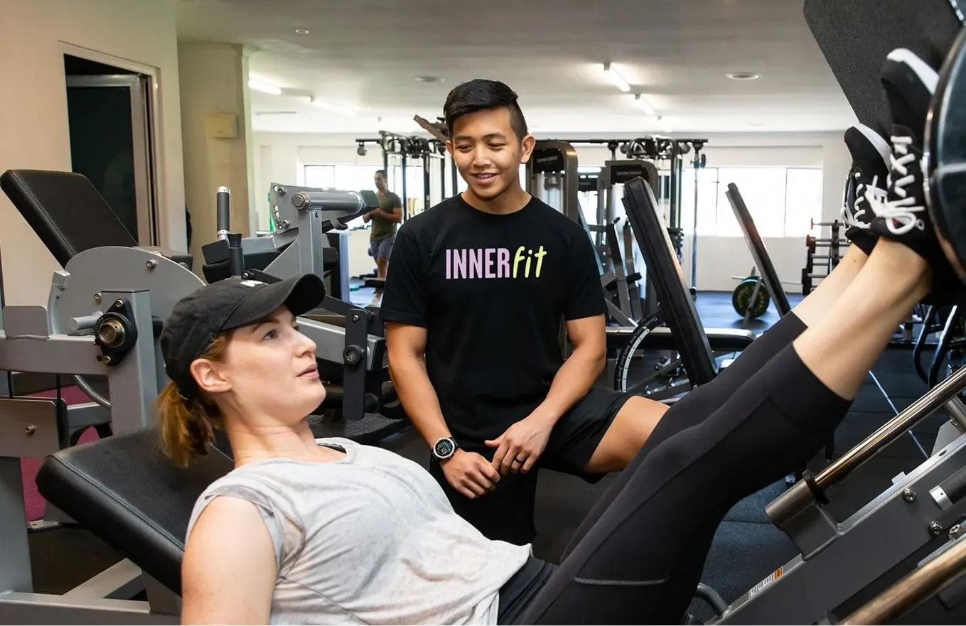 An Exercise Physiologists at InnerFit Gym working with a female trainer achieve her fitness and wellness goals